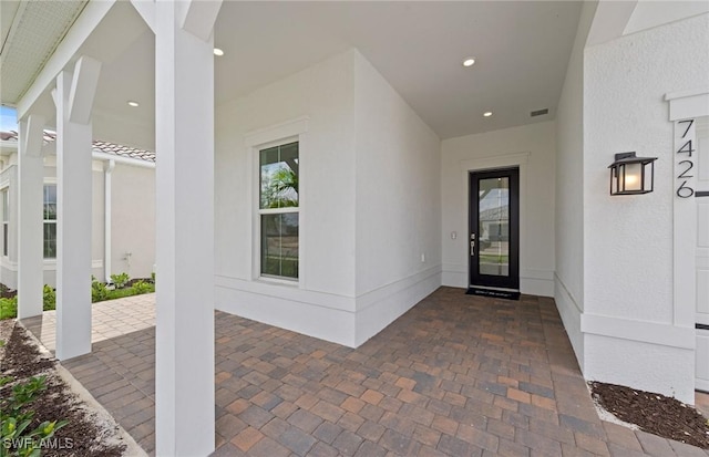 doorway to property with visible vents and stucco siding