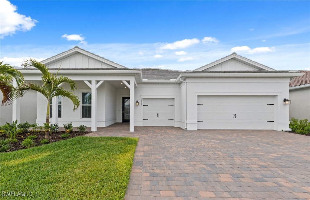 7426 Blue Salvia Dr, North Fort Myers, FL 33917 - view of front of house featuring decorative driveway, an attached garage, stucco siding, and a front yard