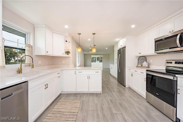 27525 Michigan St, Bonita Springs, FL 34135 - kitchen with open shelves, a sink, pendant lighting, white cabinets, and appliances with stainless steel finishes