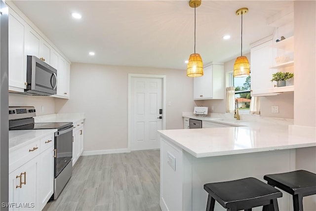 27525 Michigan St, Bonita Springs, FL 34135 - kitchen with open shelves, stainless steel appliances, light countertops, and white cabinets