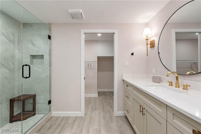 27525 Michigan St, Bonita Springs, FL 34135 - bathroom featuring a spacious closet, baseboards, vanity, and a stall shower
