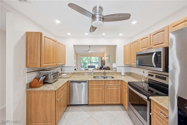 733 Landover Ct Unit 203, Naples, FL 34104 - kitchen with light stone countertops, appliances with stainless steel finishes, a ceiling fan, and a sink