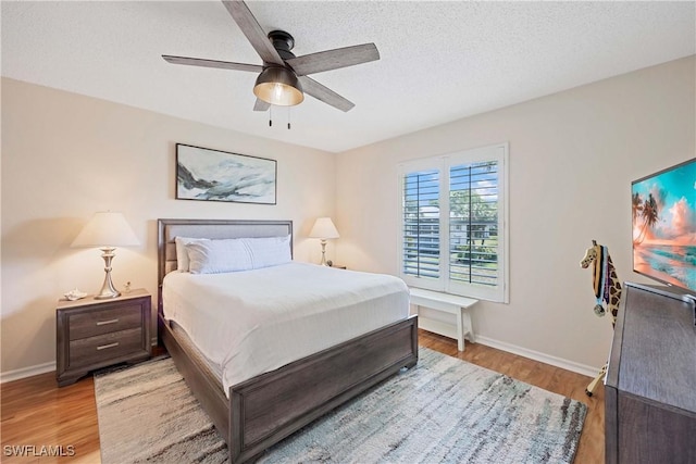 733 Landover Ct Unit 203, Naples, FL 34104 - bedroom with wood finished floors, a textured ceiling, baseboards, and ceiling fan