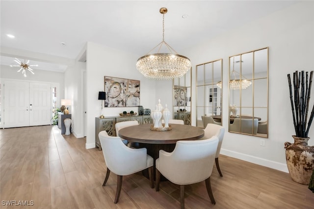 15766 Cortina St, Naples, FL 34114 - dining room featuring a chandelier, wood finished floors, and baseboards