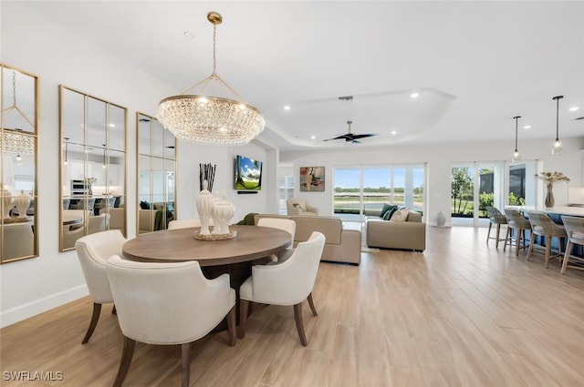 15766 Cortina St, Naples, FL 34114 - dining area featuring recessed lighting, light wood-type flooring, a chandelier, a tray ceiling, and ceiling fan