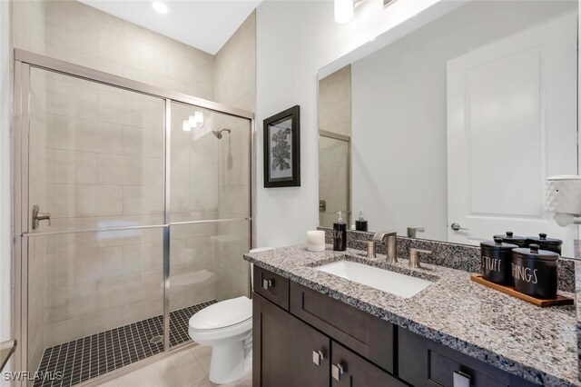 15766 Cortina St, Naples, FL 34114 - bathroom featuring vanity, toilet, a shower stall, and tile patterned flooring