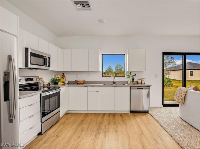 809 Bell Blvd S, Lehigh Acres, FL 33974 - kitchen featuring visible vents, a sink, white cabinetry, and appliances with stainless steel finishes