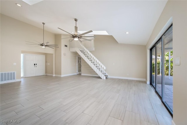 unfurnished living room with light wood-style flooring, a ceiling fan, baseboards, visible vents, and stairway