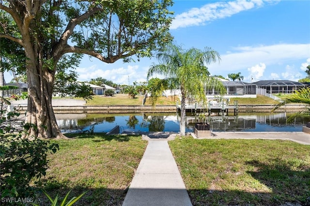view of dock with a yard and a water view