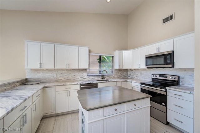 kitchen with a sink, decorative backsplash, stainless steel appliances, and visible vents