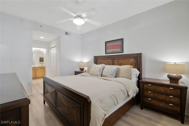 bedroom featuring visible vents, connected bathroom, light wood finished floors, and a closet