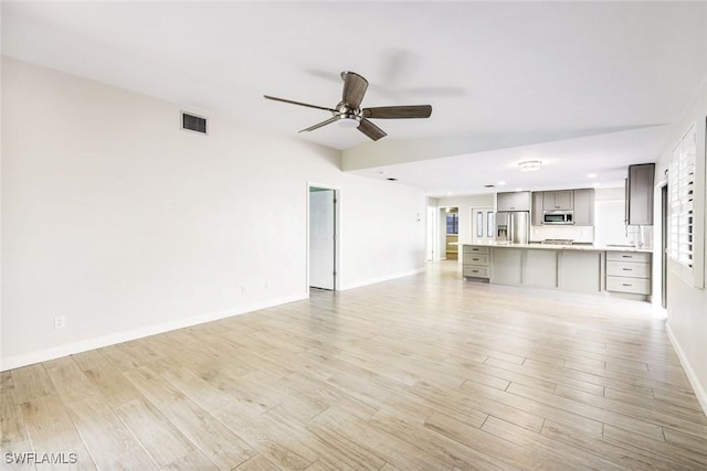 unfurnished living room with baseboards, visible vents, light wood-style floors, and ceiling fan