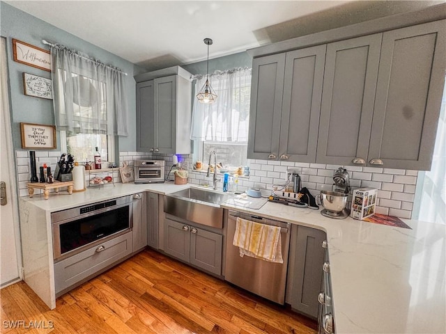 270 River Oaks Dr, Labelle, FL 33935 - kitchen featuring tasteful backsplash, dishwasher, gray cabinetry, and a sink