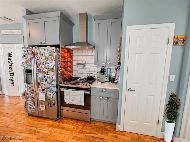 270 River Oaks Dr, Labelle, FL 33935 - kitchen with tasteful backsplash, light wood-style floors, gray cabinetry, wall chimney range hood, and appliances with stainless steel finishes