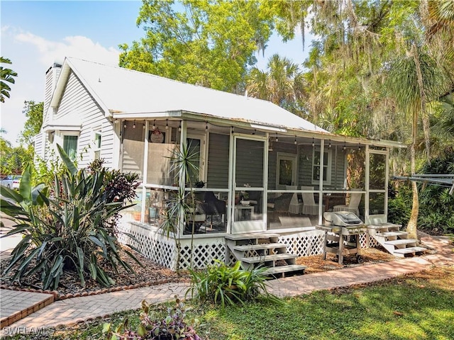 270 River Oaks Dr, Labelle, FL 33935 - back of property featuring a chimney and a sunroom