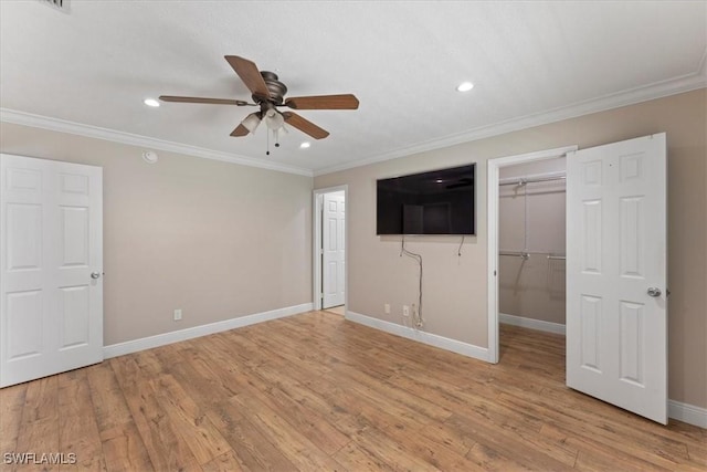unfurnished bedroom with a spacious closet, recessed lighting, crown molding, light wood-type flooring, and baseboards