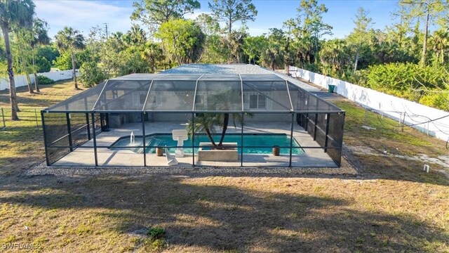view of pool with a patio, a lanai, and view of wooded area