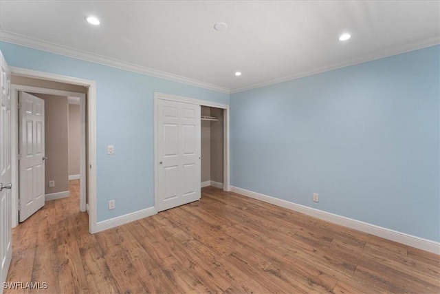 unfurnished bedroom with crown molding, baseboards, light wood finished floors, recessed lighting, and a closet