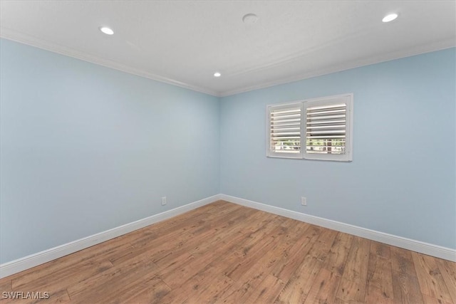 spare room with ornamental molding, baseboards, recessed lighting, and wood finished floors