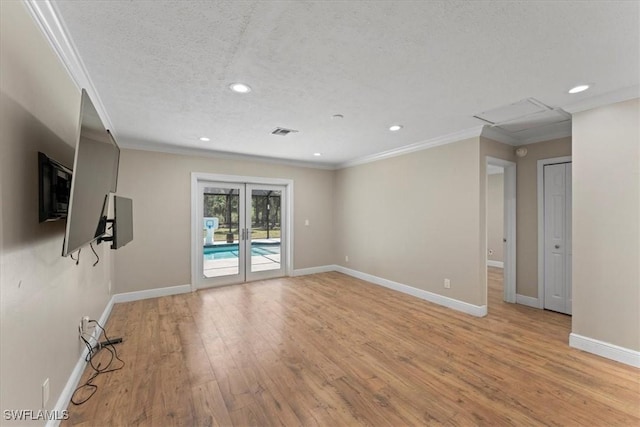 spare room with ornamental molding, recessed lighting, light wood-type flooring, baseboards, and a textured ceiling