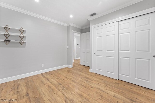 unfurnished bedroom with ornamental molding, light wood finished floors, baseboards, recessed lighting, and a closet