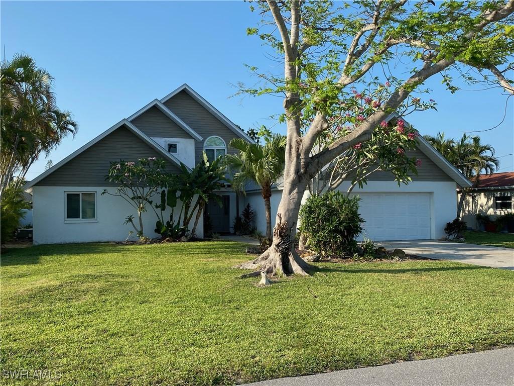 view of front of property with stucco siding, driveway, and a front lawn