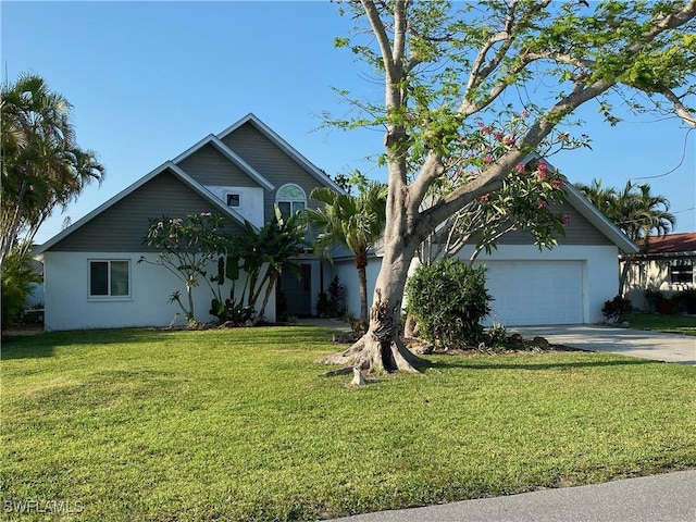 view of front of property with stucco siding, driveway, and a front lawn