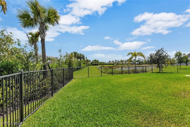 view of yard featuring a water view and a fenced backyard