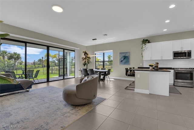 living area with baseboards, recessed lighting, light tile patterned flooring, and visible vents