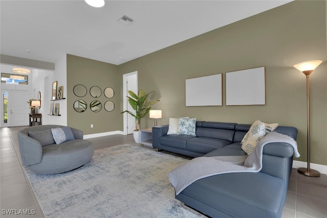 tiled living room featuring baseboards and visible vents