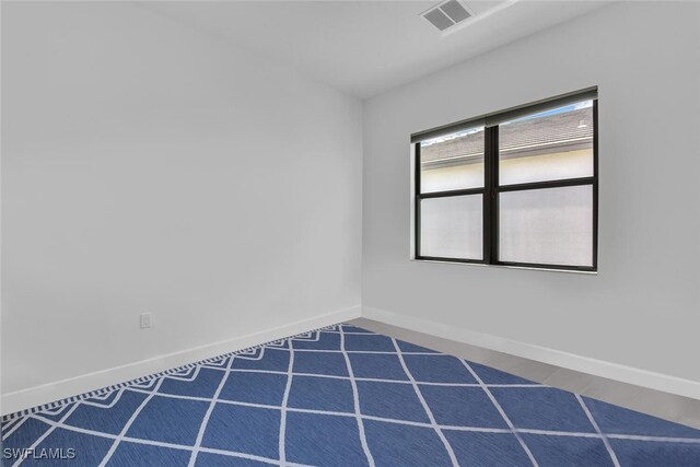 spare room with baseboards and visible vents