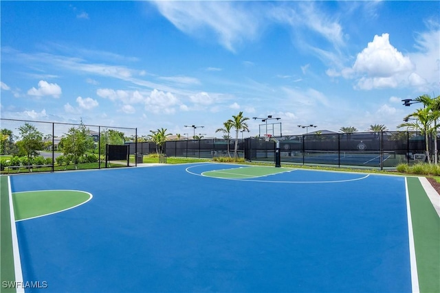 view of sport court featuring community basketball court, fence, and a tennis court