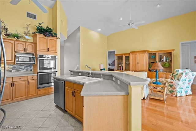 21075 Saint Peters Dr S, Fort Myers Beach, FL 33931 - kitchen featuring ceiling fan, high vaulted ceiling, a sink, appliances with stainless steel finishes, and light countertops