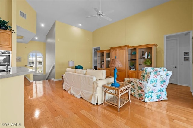 21075 Saint Peters Dr S, Fort Myers Beach, FL 33931 - living room featuring high vaulted ceiling, a ceiling fan, light wood-type flooring, and baseboards