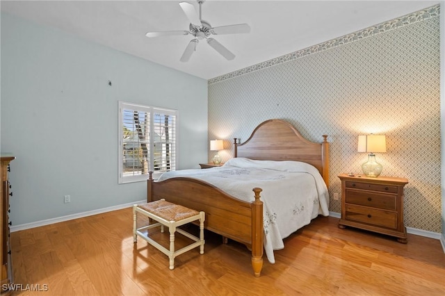 21075 Saint Peters Dr S, Fort Myers Beach, FL 33931 - bedroom with wood finished floors, baseboards, an accent wall, wallpapered walls, and ceiling fan