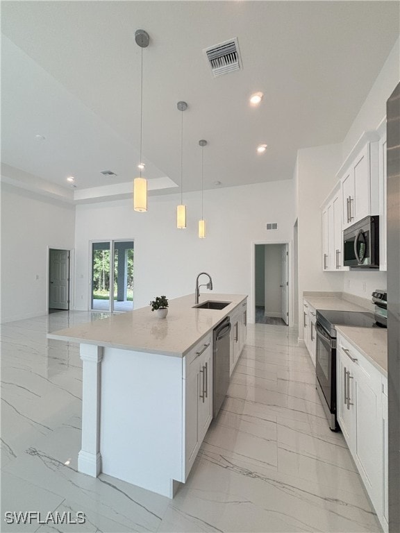 111 Monroe Ave, Lehigh Acres, FL 33936 - kitchen with stainless steel appliances, light marble finish flooring, a sink, a large island with sink, and white cabinetry