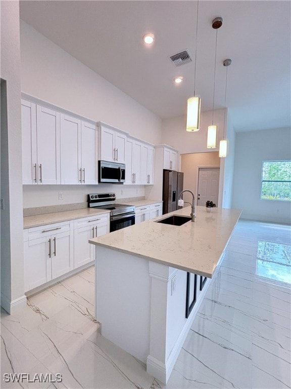 111 Monroe Ave, Lehigh Acres, FL 33936 - kitchen with appliances with stainless steel finishes, a sink, light marble finish flooring, baseboards, and white cabinetry