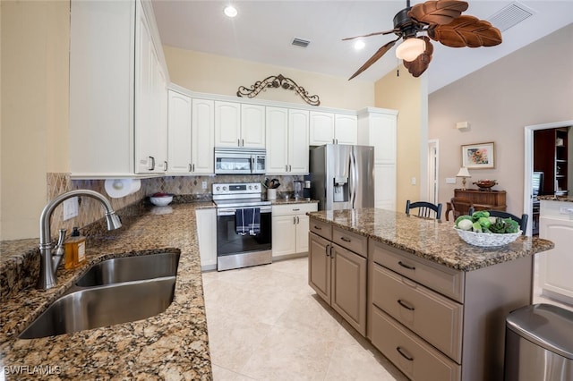 522 Countryside Dr, Naples, FL 34104 - kitchen featuring a ceiling fan, a sink, stone counters, appliances with stainless steel finishes, and a kitchen island