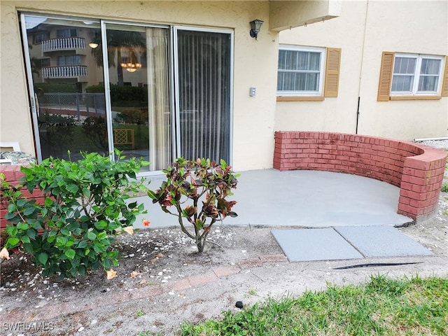 3706 Broadway Unit 5, Fort Myers, FL 33901 - view of exterior entry with stucco siding and a patio