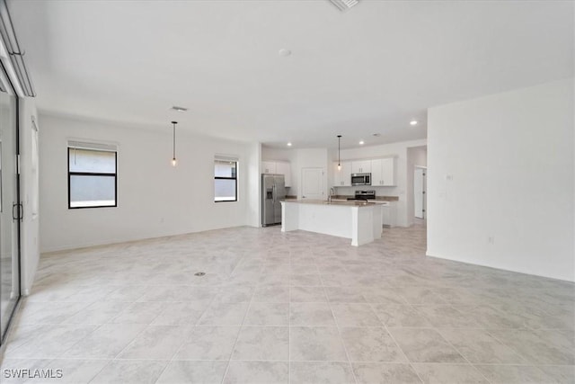 2161 Gardenia Ave, Port Charlotte, FL 33953 - unfurnished living room featuring light tile patterned floors, a wealth of natural light, and recessed lighting