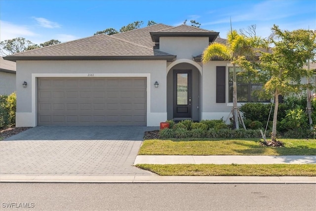 2161 Gardenia Ave, Port Charlotte, FL 33953 - view of front of property with a shingled roof, stucco siding, driveway, a front yard, and a garage