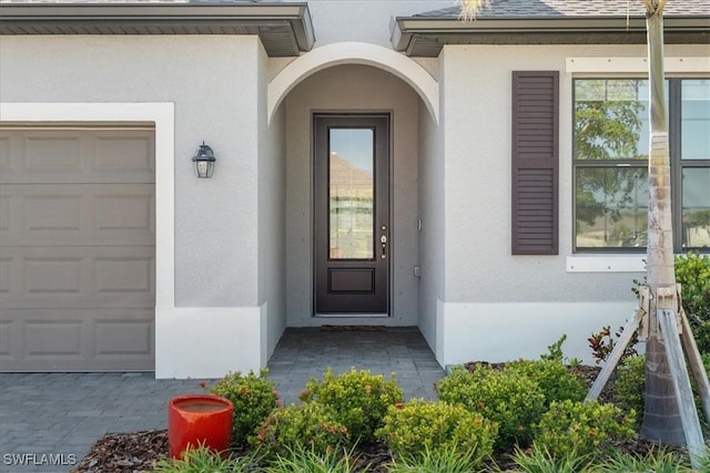 2161 Gardenia Ave, Port Charlotte, FL 33953 - entrance to property featuring a garage, roof with shingles, and stucco siding