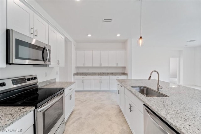 2161 Gardenia Ave, Port Charlotte, FL 33953 - kitchen with decorative light fixtures, white cabinets, appliances with stainless steel finishes, and a sink