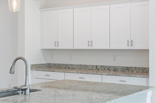 2161 Gardenia Ave, Port Charlotte, FL 33953 - kitchen featuring white cabinets, hanging light fixtures, light stone counters, and a sink