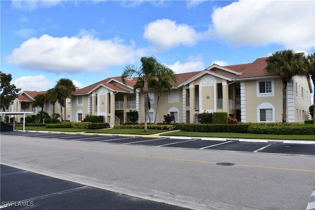 view of building exterior featuring a residential view and uncovered parking