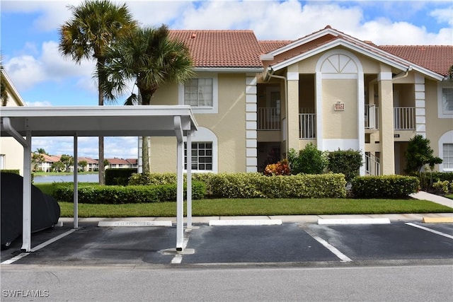 view of property with covered and uncovered parking
