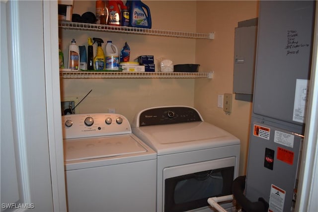 washroom featuring washer and dryer, heating unit, electric panel, and laundry area