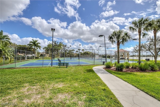 view of tennis court featuring fence, a gazebo, and a yard