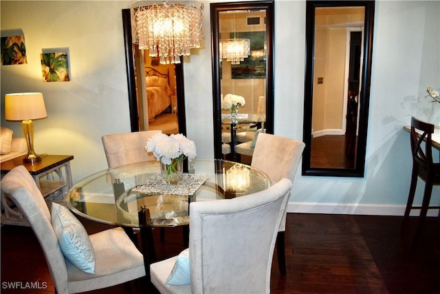 dining room featuring a chandelier, wood finished floors, and baseboards