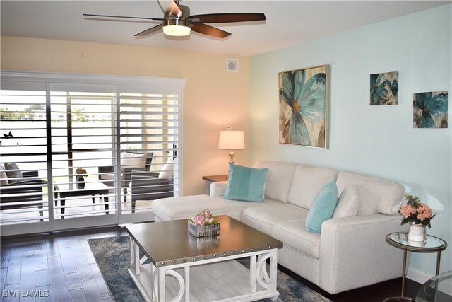living room featuring wood finished floors, visible vents, and ceiling fan